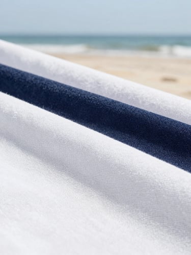 Close-up macro shot of pristine, high-end linen fabric texture, soft natural coastal daylight, clean white and deep navy tones, sharp focus, 35mm