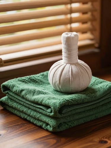 Neatly folded linen towels beside a traditional Thai herbal compress, golden-hour window light filtering through bamboo blinds, warm wooden interiors