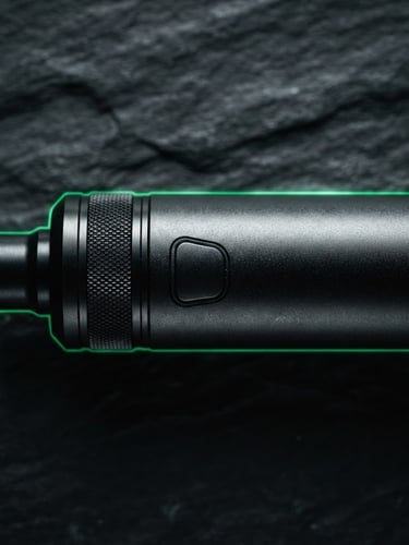 Macro close-up of a premium matte black metal vape device with emerald green rim lighting, shot on dark slate, high-contrast, 35mm
