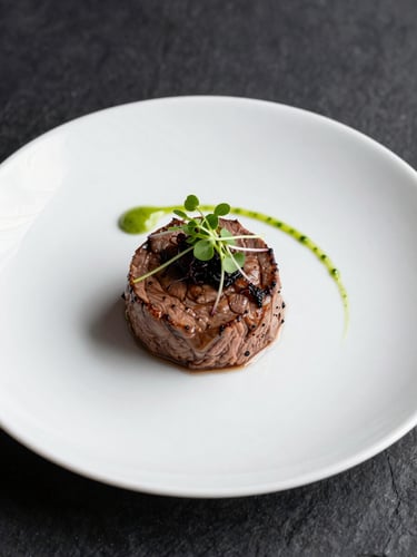 Close-up macro overhead of a single elegant dinner plate, precision-plated medallion of beef with micro-herb garnish and a thin sauce arc, studio strobe lighting, white bone china on a dark slate surface, sharp focus on the garnish detail