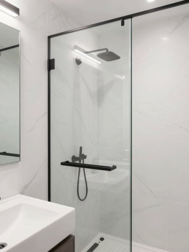 Minimalist modern bathroom with sleek black fixtures, white marble tiles, frameless glass shower, soft natural light