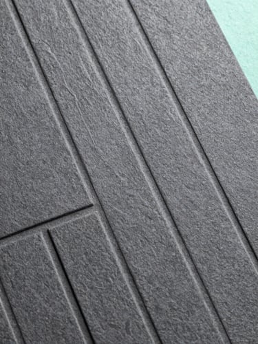 Extreme macro detail of high-end physical brand assets, textured charcoal paper debossed with clean geometric lines, cool daylight, sharp focus, Hasselblad medium format