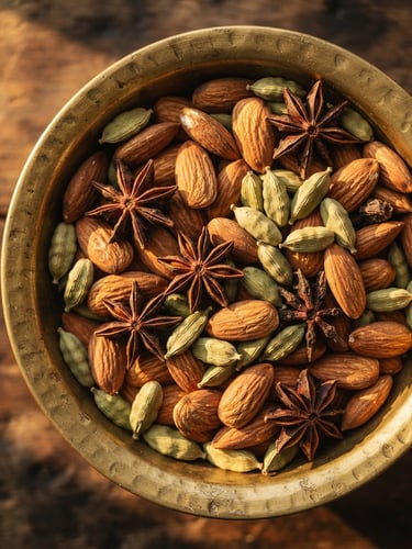 Macro overhead shot of raw almonds, cardamom pods, and star anise in a traditional brass bowl, warm golden-hour side lighting, deep shadows