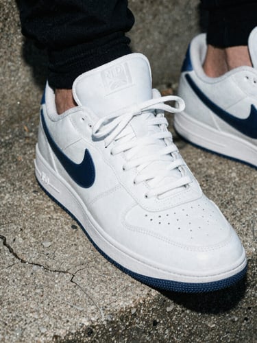 Raw flash photography, extreme close-up of high-end sneakers resting on a cracked concrete step, gloomy overcast daylight, high contrast, gritty 35mm film grain