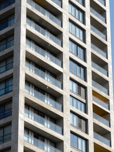 Architectural elevation of a modern residential tower in Bogotá, sharp focus, geometric concrete lines, bright daylight.