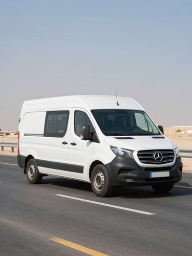 Dynamic low-angle shot of a clean white delivery van driving on a highway in Abu Dhabi, bright midday desert light, sharp focus, 35mm