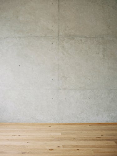Minimalist concrete wall meeting a warm oak floor, soft diffused overcast daylight casting gentle shadows, medium format film aesthetic, 80mm.