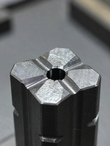 Macro close-up of finished steel press tools showing precise tool paths, cool metallic highlights, sharp reflections, clean organized factory background, 35mm