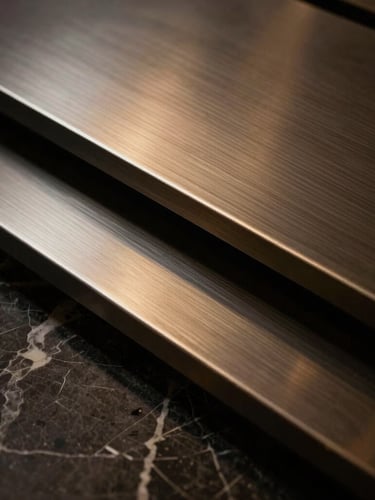 Dramatic low-key close-up of high-end materials like brushed steel and dark marble, sharp architectural focus, 35mm editorial luxury photography