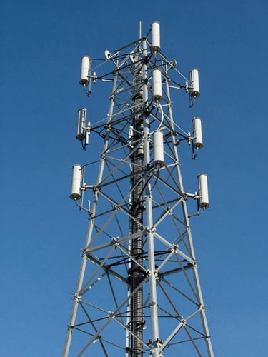 Low-angle heroic shot of a transmission tower against a clear blue sky, sharp focus, professional industrial photography