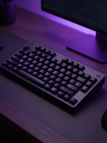 Close-up of a modern workspace in Belfast, moody low-key studio lighting with subtle violet ambient backlighting, high-contrast shadows, 35mm