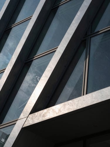 Macro shot of modern architectural steel and glass structure, sharp geometric lines, high-contrast dramatic studio lighting with deep shadows