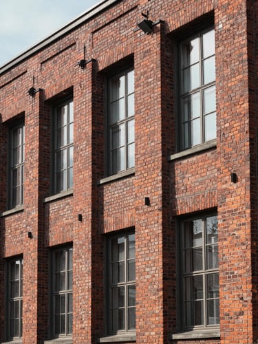 Architectural detail of a classic brick factory facade in northern Germany, clean lines, soft natural daylight, deep realistic shadows.