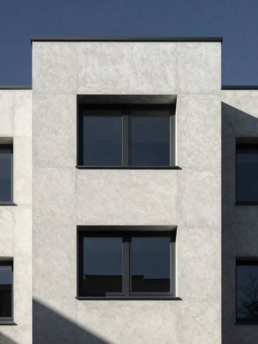 Minimalist architectural elevation of a contemporary European residential building, clean concrete lines, sharp morning shadows, 35mm style