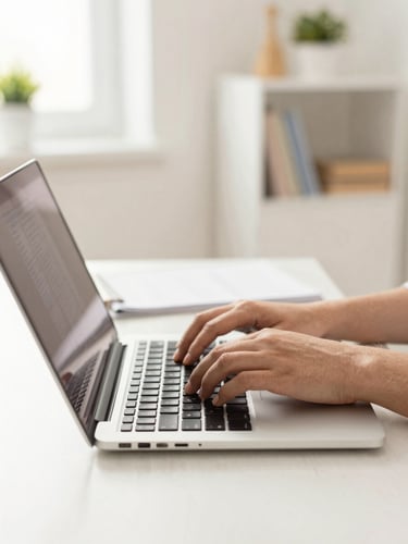 Bright editorial photography of hands typing on a laptop in a clean home office setting, warm natural daylight, friendly tech atmosphere