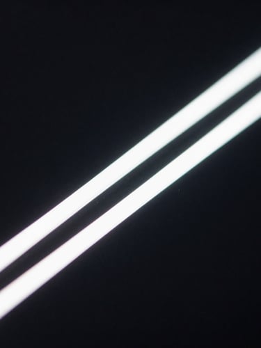 Extreme macro close-up of a high-resolution interface detail, sharp glowing lines, deep black background