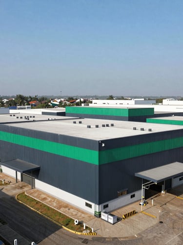 Wide environmental shot of the expansive Accra industrial facility, clean modern architecture under sharp daylight, high-contrast shadows, 35mm lens