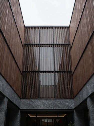 Symmetrical minimalist architectural crop of a luxury hotel atrium, soft overcast daylight, desaturated slate and bronze tones, medium format camera