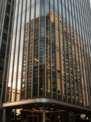 Architectural detail of a modern, high-end corporate law office in São Paulo, sharp glass reflections, warm side-lighting, deep shadows, professional atmosphere.