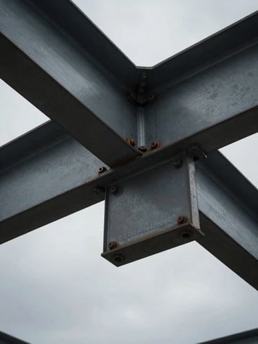 Close-up of structural steel beams bolted together, overcast grey sky background, high contrast, industrial texture.