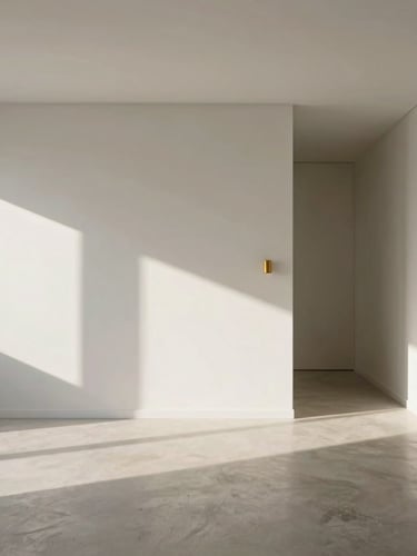 Architectural photography of a minimalist Lisbon apartment interior, soft morning sunlight casting long shadows across microcement floors and clean white walls, a single brushed gold fixture visible, wide-angle cinematic framing.