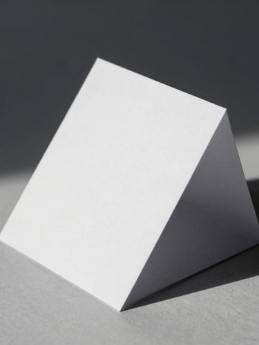 Macro studio photograph of crisp white folded paper prototype, sharp geometric lines, hard directional side-light, dramatic dark shadows, architectural angles
