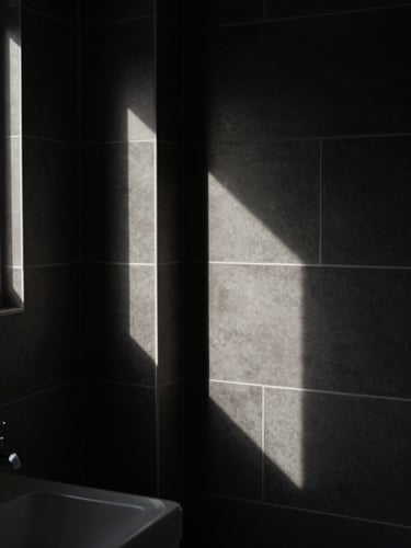 Moody architectural photography of a modern bathroom, sharp geometric tile lines, high-contrast directional lighting, deep shadows, 35mm tilt-shift lens.