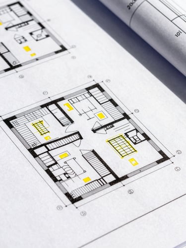 Close-up of architectural blueprints with yellow technical universal design annotations, high-contrast daylight, clean lines