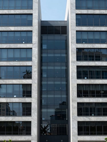 Symmetrical portrait of modern corporate architecture in Mexico City, clean lines, slate gray and deep blue glass facade, cool natural daylight, 35mm