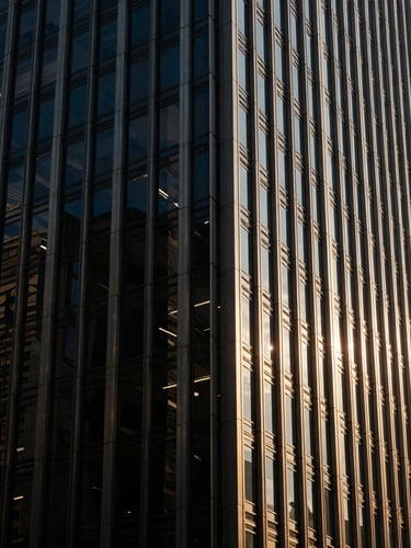 Low-key dramatic side-lighting on the architectural steel and glass facade of a major Singapore financial hub, deep navy shadows, sharp focus, 35mm.