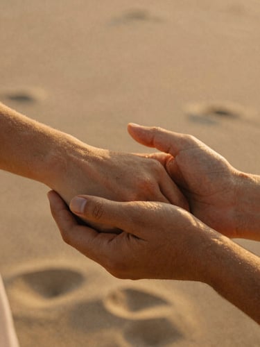 Intimate close-up of hands holding, warm golden-hour backlighting, soft sand and terracotta tones, 35mm film texture.