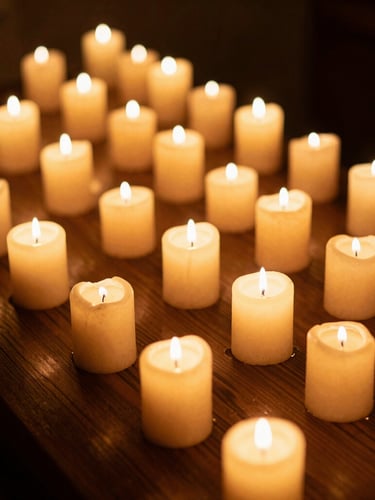 Warm editorial portrait of a candlelit spa chamber, low-key golden candlelight, deep shadows, rich wood tones, shallow depth of field, 35mm