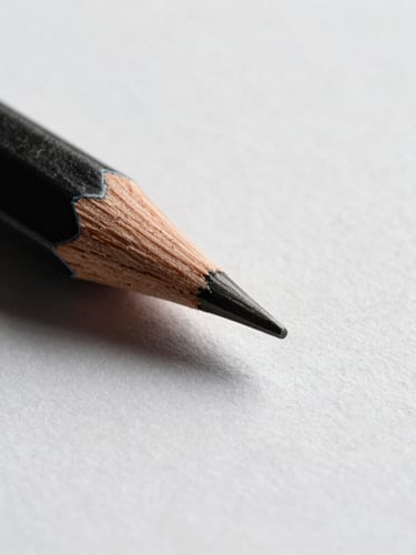 Macro close-up of a sharp graphite pencil tip touching textured heavy-weight paper, high-contrast side-lighting, warm cedar wood grain visible, minimalist monochrome studio shot.