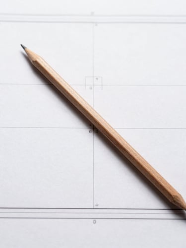 Overhead flat lay of technical blueprints with a single wooden pencil resting diagonally across crisp white lines, sharp shadows, minimalist studio lighting