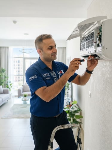 A professional clean-cut technician in a blue uniform working on a modern AC unit inside a bright UAE home, crisp details, 35mm lens