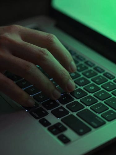 Hands interacting with a sleek, dark-mode laptop keyboard, illuminated by a subtle electric-green glow from the screen, macro lens detail.