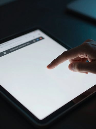 Close-up of an educator interacting with a clean digital interface on a tablet, low-key ambient lighting with sharp directional cyan highlights, shallow depth of field, 35mm