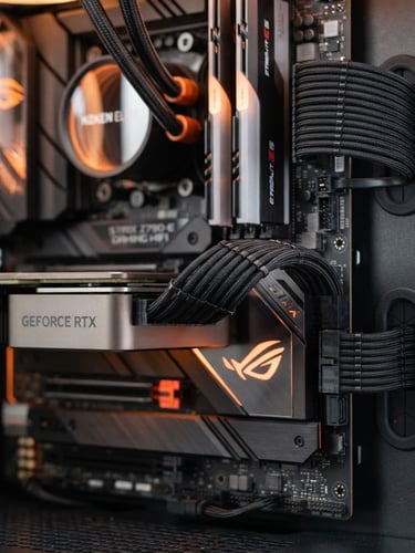 Sharp macro product photography of clean cable routing inside a custom PC, pristine motherboard components, high-key studio lighting with subtle orange accent glows reflecting off metallic surfaces, shallow depth of field.