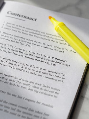 Extreme close-up of a contract page lying flat on a marble surface, margin annotations in pencil visible beside printed clauses, a yellow highlighter uncapped resting diagonally across the page, soft diffused daylight from the left creating true shadows in the paper texture