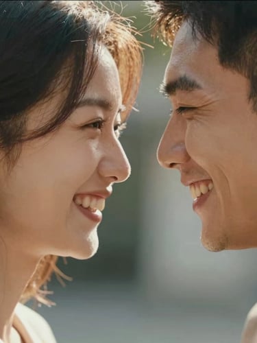 Intimate close-up portrait of a couple laughing, foreheads touching, warm sun filtering through their hair, soft focus, cinematic 16:9 framing