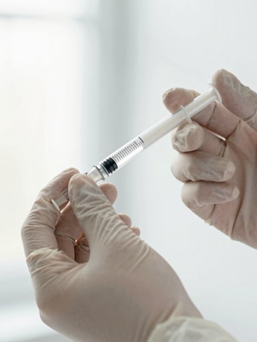 Close-up of a precise clinical procedure, sterile gloved hand holding a syringe, bright clinical daylight, soft desaturated tones, shallow depth of field