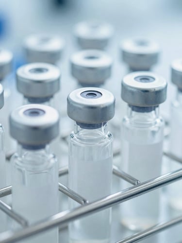 Close-up of sterile specimen transport vials arranged in a cool-toned metal rack, bright clinical laboratory lighting, sharp macro focus