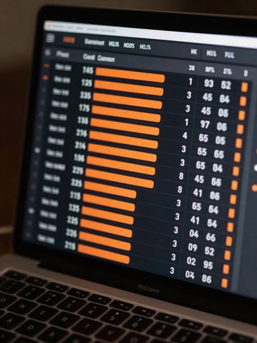 Extreme close-up of a laptop screen displaying a sports analysis dashboard — odds columns, confidence percentage bars in orange, match statistics rows — under sharp studio light, no hands, no face, just the data in high contrast