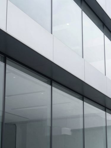 Sharp architectural close-up of a modern corporate boardroom with clean lines and structured glass panels, bright neutral daylight, cool gray tones