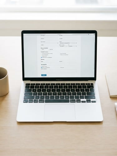 Overhead flat-lay of a clean minimalist desk, open laptop showing a structured job application form, bright high-key natural daylight, crisp details, 35mm
