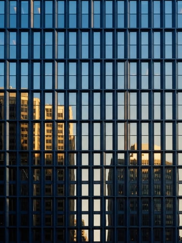 Sharp architectural crop of modern corporate office facade, deep navy steel framing and high-contrast glass reflecting morning light, minimalist composition, 35mm