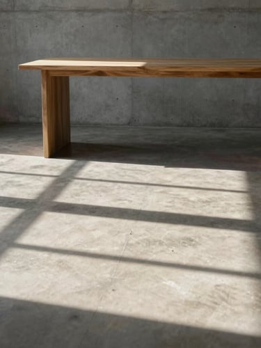 Flat-on architectural crop of a raw concrete studio interior, hard afternoon sunlight casting sharp geometric shadows across a polished concrete floor, minimalist timber desk in the background.