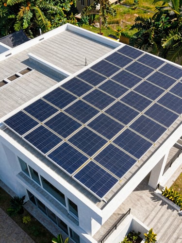 A high-angle architectural photograph of a modern Hyderabad villa roof with perfectly aligned tier-1 solar panels under bright Indian noon sunlight.
