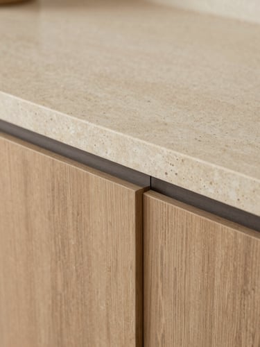 Close-up detail shot of custom oak joinery meeting a raw travertine stone countertop, soft diffused daylight, warm architectural photography