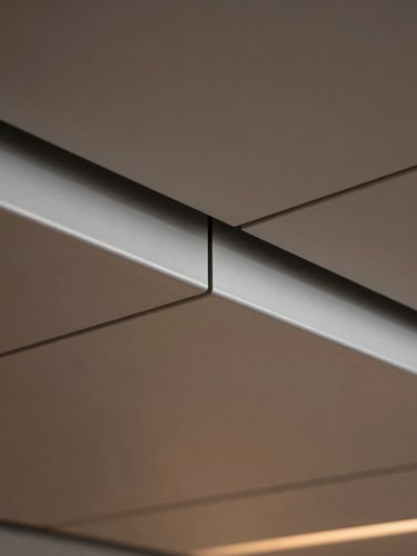Macro close-up of a seamless aluminum joint under-deck ceiling, showing clean architectural lines, precise interlocking metal panels, soft dramatic lighting, sharp focus, 35mm.